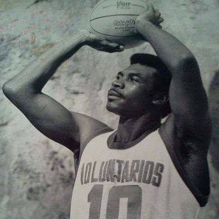 Fred Hare Sr. in his number 10 jersey, holding a basketball overhead